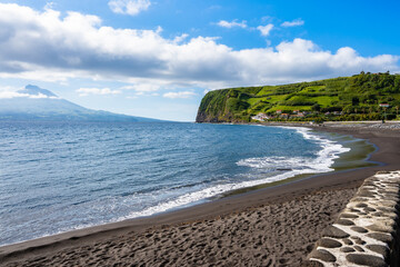 Almoxarife beach with ocean and Pico volcano in background on coast of Faial island, Azores, Portugal