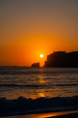 A spectacular sunset features a fiery orange sun dipping towards the horizon over the Atlantic...