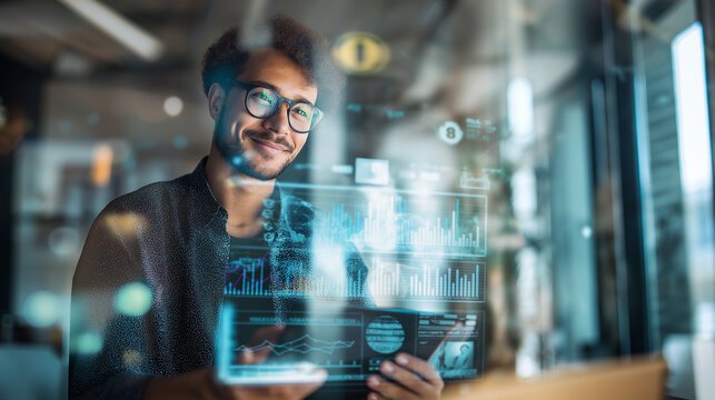 Smiling man interacting with futuristic digital interface on a transparent screen in a modern office environment.
