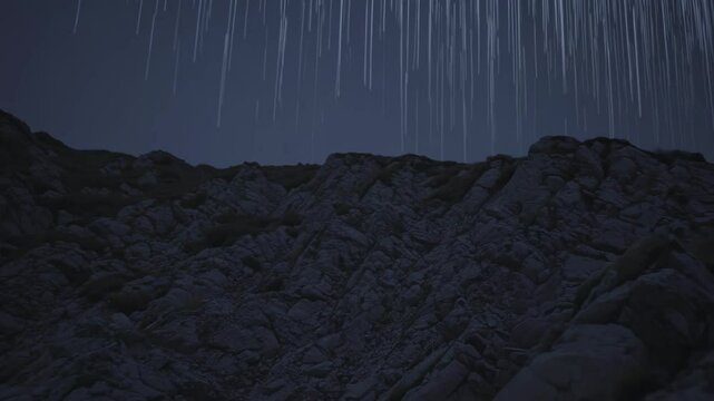 Vertical streaks of light falling over dark rocky mountains in night landscape

