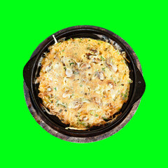 Okonomiyaki Dish: A top-down, detailed view captures the enticing Okonomiyaki dish served in a rustic black pan, sitting in front of a clean green background, the savory dish's textures.