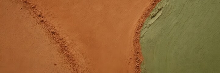Aerial view of rich orange soil meeting vibrant green vegetation, showcasing striking contrast and natural textures that highlight the beauty of earth’s diverse landscapes. 