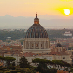 Twilight scene over Vatican City, the famous dome of St. Peter’s Basilica illuminated by setting sun, with layers of city and distant hills beneath it.Travel concept