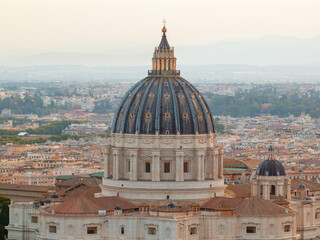 Sunrise over St. Peter’s Basilica dome in Vatican City, with Rome skyline and distant mountains, iconic architectural symbol of Christianity and European heritage. Travel concept