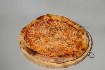 Top view of a gourmet pizza topped with roast beef, porcini mushrooms, tomatoe sauce, and mozzarella cheese, beautifully presented on a light grey background.