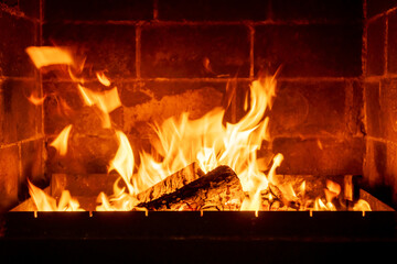 Flames dancing above burning logs in indoor fireplace, classic stone hearth, fire heat glow, cabin comfort, rustic design, warm home scene, intimate winter vibe
