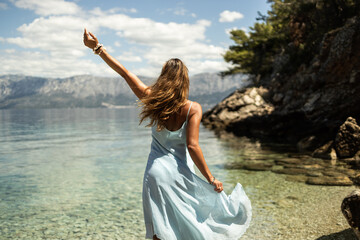 Woman In Blue Dress Enjoying A Summer Day At The Beach