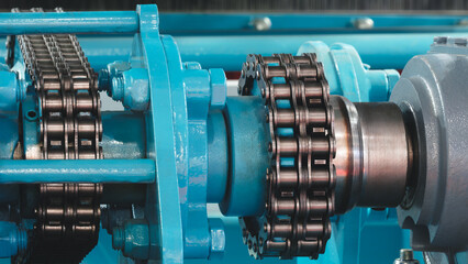 Drive is a blue machine with a chain and gears. chain is black and the gears are silver industrial concept background