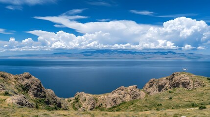 Fototapeta premium Stunning Lake and Mountain Landscape under Blue Sky with Puffy Clouds