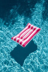 Naklejka premium Pink and White Striped Pool Float Rests in Clear Blue Water on a Sunny Day