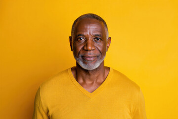 Obraz premium Portrait of a Confident Senior Man with Graying Hair Against a Bright Yellow Background, Radiating Wisdom and Life Experience