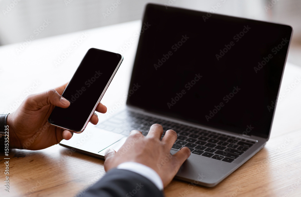 Poster closeup of unrecognizable african american businessman using smartphone and modern laptop with empty