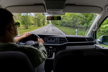 Driving spring highway. Man at wheel. Car cabin perspective.