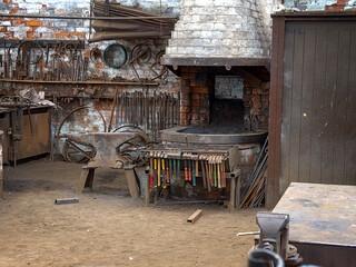Rustic blacksmith workshop with tools and forge.