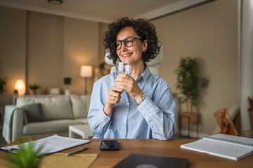 Beautiful mature businesswoman drink glass of water in the office at home