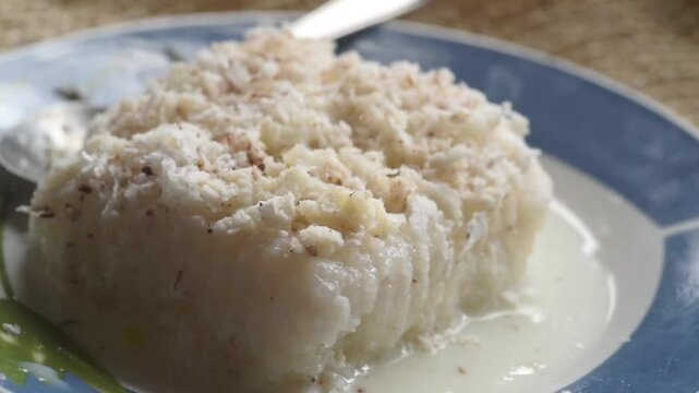 Brazilian traditional dessert: sweet couscous (tapioca) pudding (cuscuz doce) with coconut on a rotating dessert plate.
