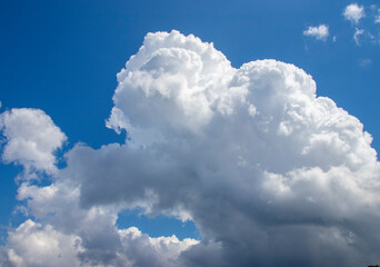 Majestic cumulus clouds against a vibrant blue sky. A captivating view of large, fluffy cumulus...