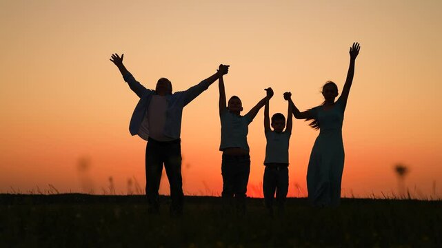 Happy family parents children raise hands outdoors at sunset. Teamwork group of people standing in nature park sun sky. Group prayer of sun. Family celebration. Parents Mom dad of child holding hands