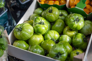 Green Zebra Tomatoes are Displayed in a Crate at a Market.