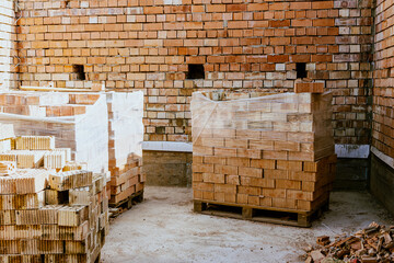 Building materials are on floor, stack red bricks. Production high-quality ceramic brick matte,...