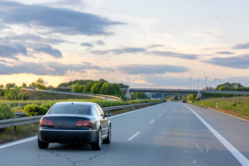 Car on highway. Road through greenery. Evening drive