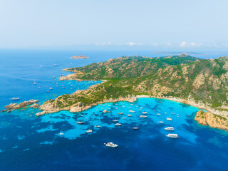Island in the middle of the sea. Drone view of a yachts, boats and island. Vacationing people. North-Eastern Sardinia, Maddalena Archipelago. Vacation and holidays. Background, wallpaper, postcard.