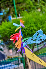 Colorful garlands of papel picado, traditional paper flags, sway gently in the breeze, adding vibrant decoration to a lively street celebration in Latin America, enhancing festive atmosphere