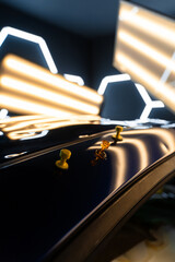 Multiple glue tabs applied to a dented car roof under LED lights during the paintless dent repair...