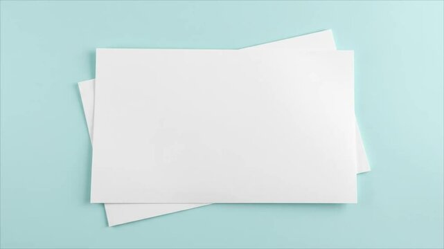 Blank white sheets of paper stacked on a light blue background  