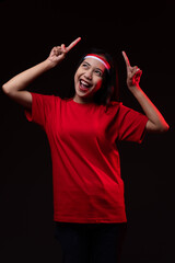 Fototapeta premium Portrait of Young Asian Woman Pointing Up Wearing Red Outfit, Indonesian Independence Day Concept