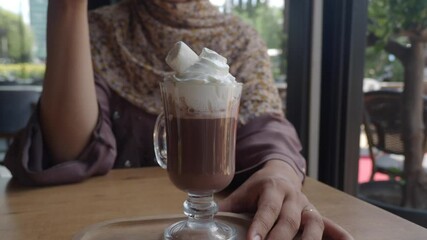 Enjoying hot chocolate topped with cream in a cafe - Powered by Adobe