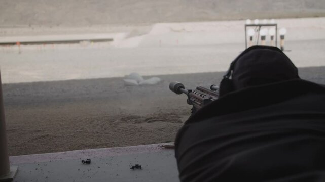 Slow motion close up of machine gun shooting at targets