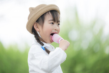 屋外でアイスを食べる幼児の女の子