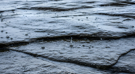 Rain Pattering On Wet Pavement Creates Textured Surface With Splashes