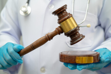 Doctor holding judge gavel, forensic medicine, medical law and crime justice concept.