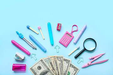 Alarm clock with money and different stationery on blue background