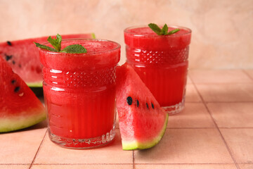 Glasses of tasty watermelon juice with mint on pink tile table