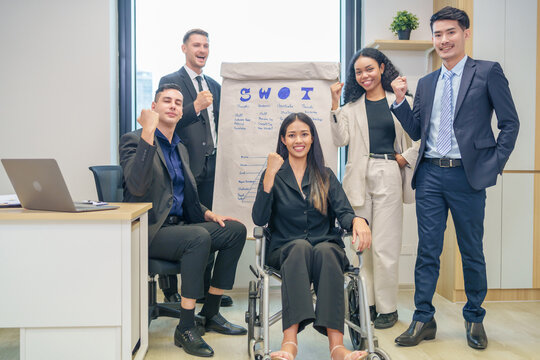 corporate diverse business people and business person with disability meeting, discussing,analysis new business strategy by using flipchart in boardroom