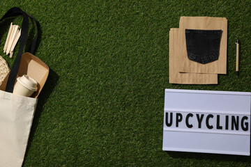 Light box with text, bag and materials for upcycling on green background, space for text