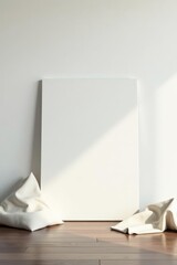Blank Canvas Leaning Against Wall with Soft White Fabrics on Hardwood Floor