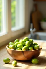 Sunlit kitchen countertop showcasing a wooden bowl brimming with vibrant green fruits, illuminated by natural light streaming through a nearby window.