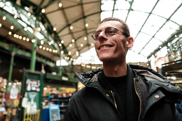 Smiling tourist exploring borough market in london
