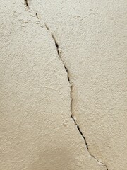 old wall background, The cement wall painted in cream color has cracks.