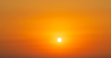 Spectacular sunrise on the horizon with the sea at your feet. Romantic sunrise. Beach sunrises. The sun tries to rise through the clouds in the orange sunrise. Travel and landscape concept.