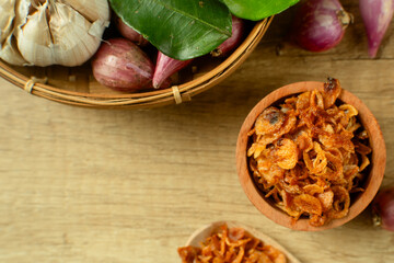 Bawang Goreng or Fried red onions in a wooden bowl. Crispy onion fries or shallots are fried to a...
