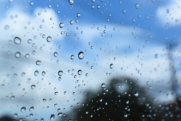 water drop on mirror with blue sky and white cloud background