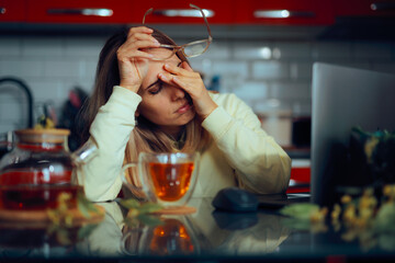Stressed Woman Working From Home Drinks Tea to Relax. Unhappy lady feeling overworked and in pain due to stress 