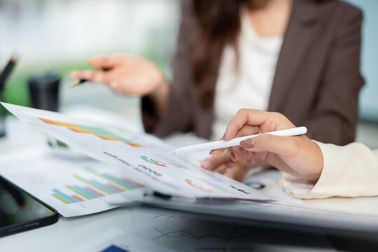 Business team working in office with graph documents on desks, planning, analyzing financial reports in conference room, brainstorming, discussing and analyzing business strategies.