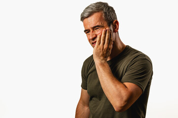 Man expressing discomfort while touching his face in a studio