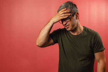 Man expressing frustration in front of a red backdrop